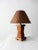 This mid 20th century vintage lodge style table lamp features a blocky wooden base with a woven wicker shade. Its classic...