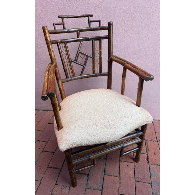 Antique English bamboo arm chair. Bamboo is finished with brass detailed caps. Original silk upholstered seat. Brighton...