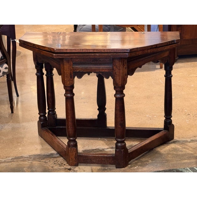 Charles II oak gate-leg table with a shaped drop-leaf top showing surface wear and patina consistent with age and use. The...