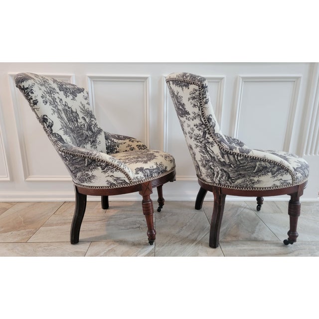 A striking matched pair of antique Victorian parlor/slipper chairs dating to approximately the turn of the 20th century,...