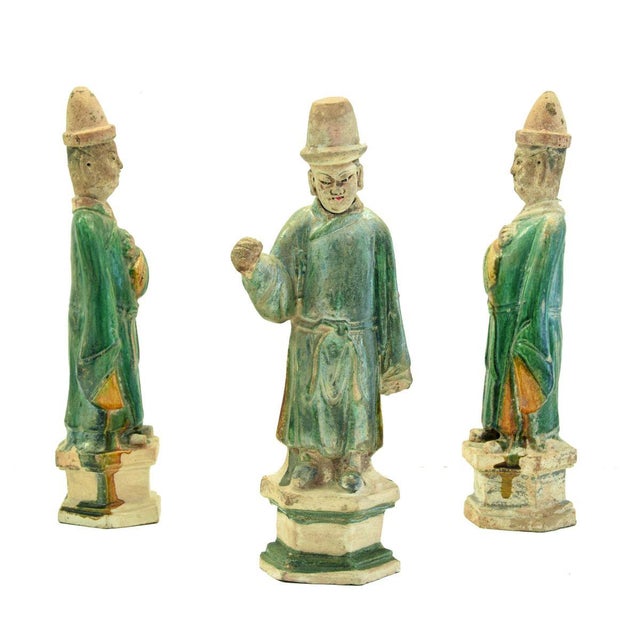 This Chinese terracotta group of figures is made up of three figures of Chinese dignitaries in glazed green and ocher...