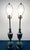 A commanding pair of heavy cast metal lamps showcasing a refined Neoclassical silhouette. The urn-form bodies feature deep...