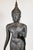 A beautiful, circa 1920, cast bronze Buddha in mid-stride atop a stylized lotus blossom. The figure is clad in see-through...