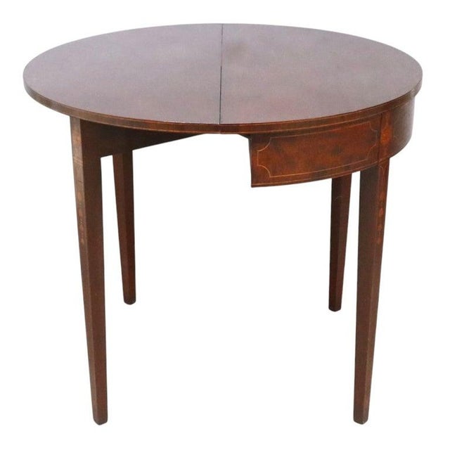 This antique Classical Hepplewhite style card table is crafted from mahogany and features intricate inlay work. The table...