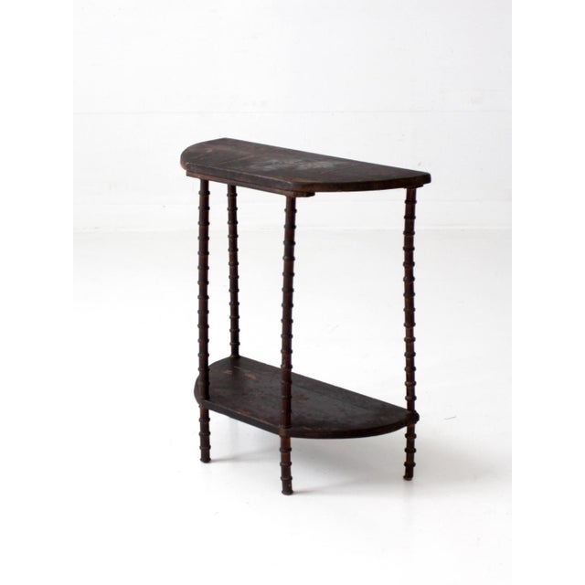 An antique primitive folk art spool table with a sculptural silhouette and beautifully graphic proportions. Slender spool-...