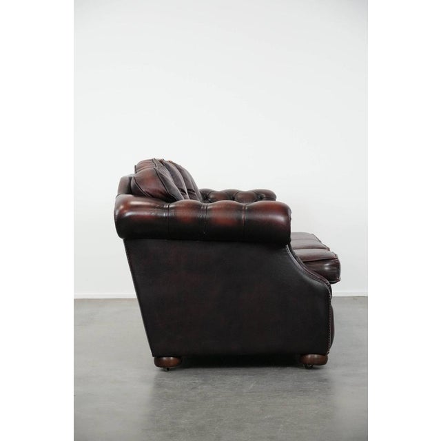 Beautiful red 2.5-seater English-style Chesterfield sofa on casters, made of thick cowhide. : This beautiful 2.5-seater...