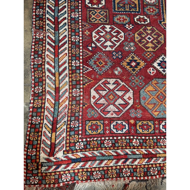 A powerful antique Ghoochan Kordi rug handwoven in northeastern Persia, showcasing bold tribal geometry and rich symbolic...