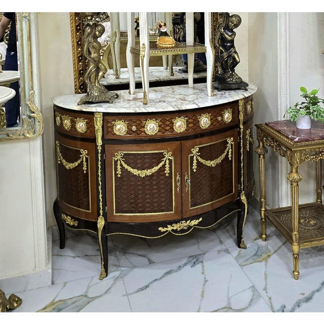 Bring timeless French elegance into your home with this magnificent Louis XVI-style demilune sideboard cabinet. Crafted...