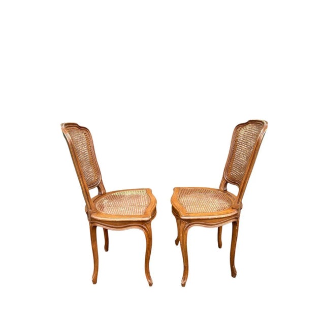 This set of two solid wood frame accent chairs features beautifully curved cabriole legs, hand-carved frames, and woven...