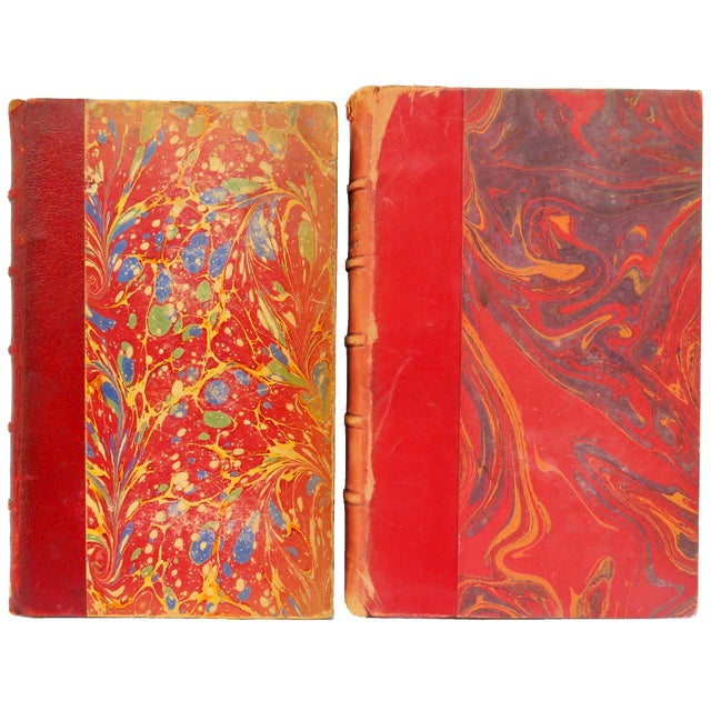 Elegant set of 7 antique red and gilt leather-bound French books with distressed bindings and covers. Some have marbelized...