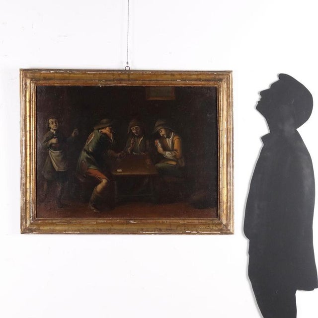 Oil on canvas. Inside a tavern, some customers are playing cards: the man sitting on the left cheats, hiding a card in the...