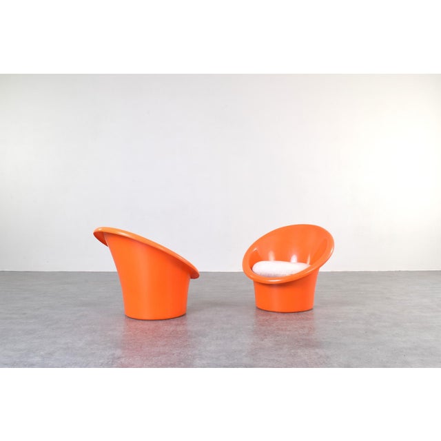 This set of two orange lounge chairs „Skopa” model was designed in the 1970s by renowned Danish designers Ole Gjerløv-...