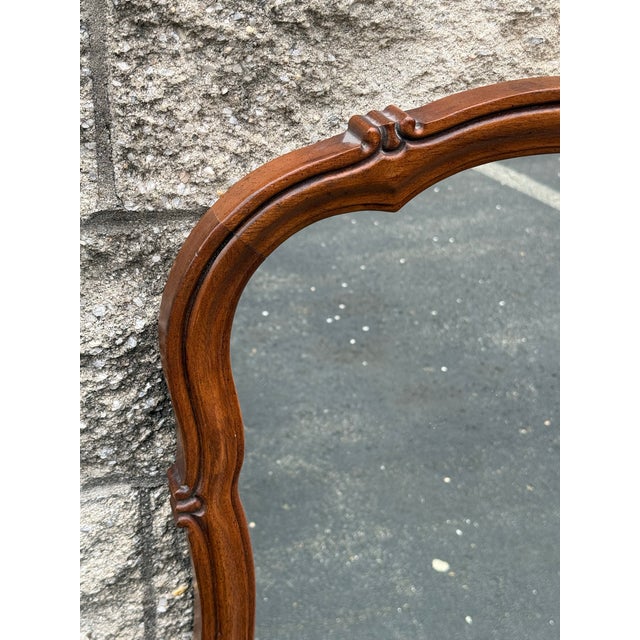 Beautiful vintage wood-framed wall mirror featuring a scalloped French Provincial design, solid wood frame. Made in the USA.