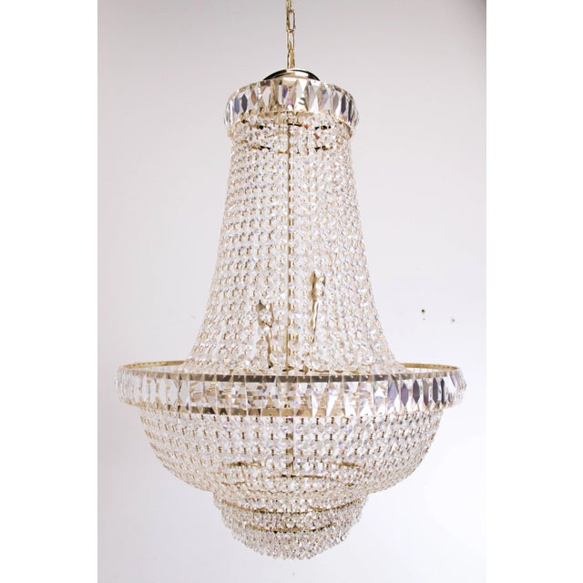 Nine-light crystal chandelier. The chandelier is in good vintage condition with signs of wear due to age. Dimensions: 24"...