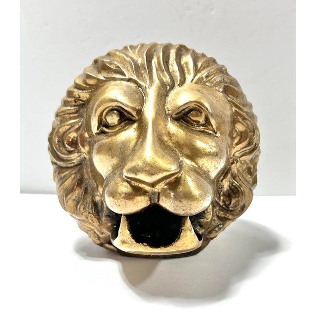 A striking solid brass lion head paperweight featuring beautifully sculpted mane details and a strong, expressive profile....