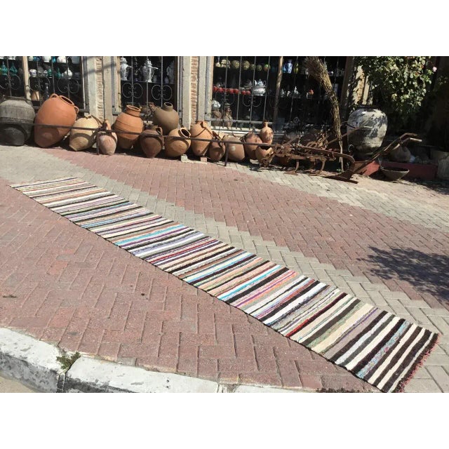 Vintage, handwoven Turkish Kilim is approximately 60 years old. It is handmade of cotton and fabric. It has been...