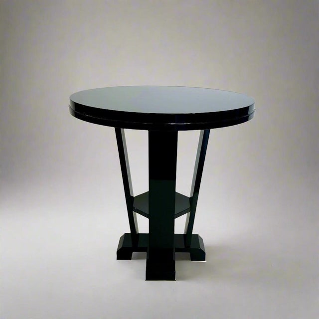 Art Deco style Gueridon. Black lacquer finish on four legs with center shelf. Late 20th Century. Feet are finished with...