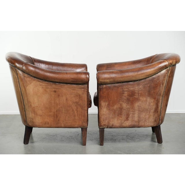This set of 2 sturdy vintage sheepskin club armchairs has a cool look and a comfortable seat. They feature loose seat...