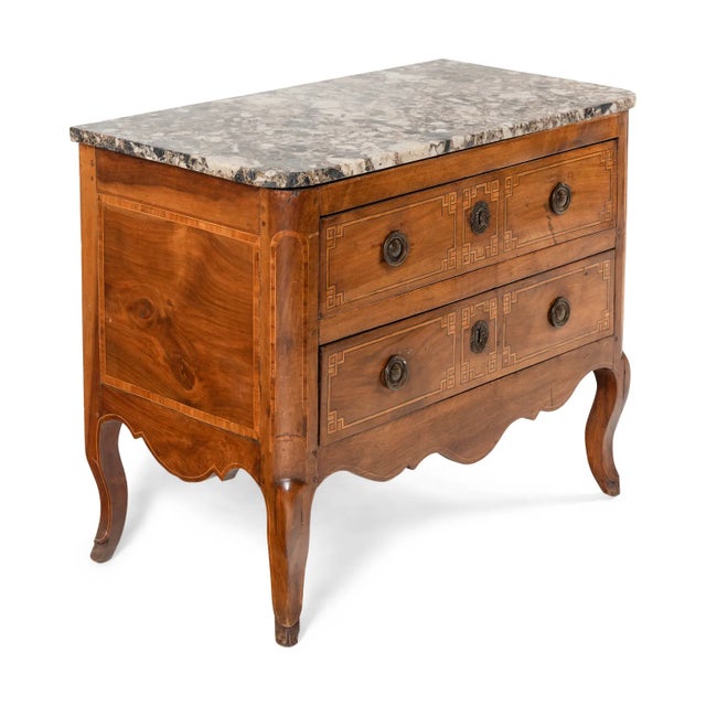 An elegant Louis XVI period commode dating to the late 18th century, crafted in richly figured walnut and retaining a...