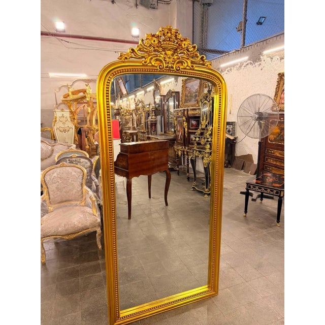 A spectacular oversized French Louis XV-style floor mirror, designed to bring the dramatic elegance of a grand European...