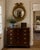 A handsome mid-20th-century American Federal-style convex mirror with a richly gilt frame, carved eagle crest, and layered...