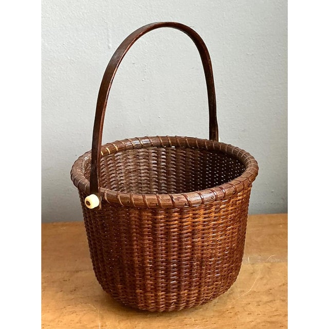 This vintage woven Nantucket basket presents a classic, softly tapered cylindrical silhouette crowned by a tall,...