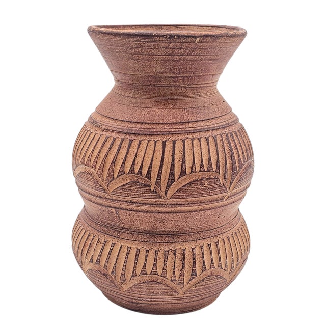 Earth, shaped by patient hands, whispers its story in grooved lines and quiet symmetry. The clay, unglazed and warm,...