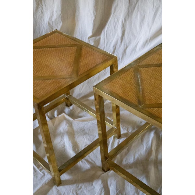 Pair of 1970s side tables featuring a geometric square-section brass frame. Clear glass tops with woven rush underneath,...