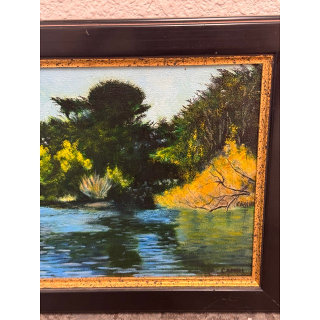 Design Plus Gallery presents an Original Lakeside Landscape Oil Painting by artist Camhi. The composition depicts calm...