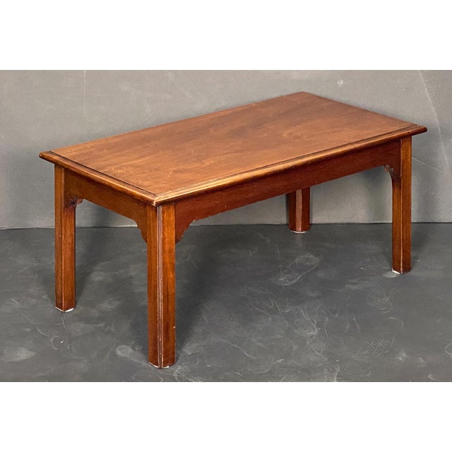 A fine French coffee or cocktail low table of patinated mahogany featuring a moulded rectangular top with a beveled edge,...
