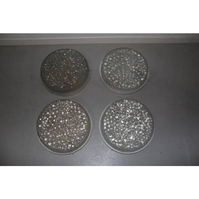 This set of four sconces in lacquered metal with bubbled glass dates to the 1960s. Up to 250V (Europe/UK Standard).The...