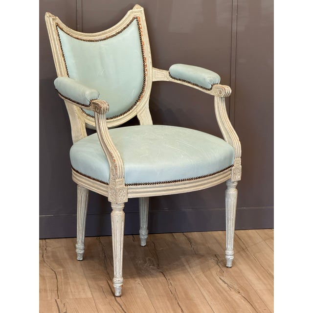 A late 18th century Swedish Gustav III armchair, white-painted with carved floral details and reeded legs. The shield-form...