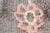 This is a vintage Turkish Oushak rug from the Mid 20th Century. The piece was hand-knotted.