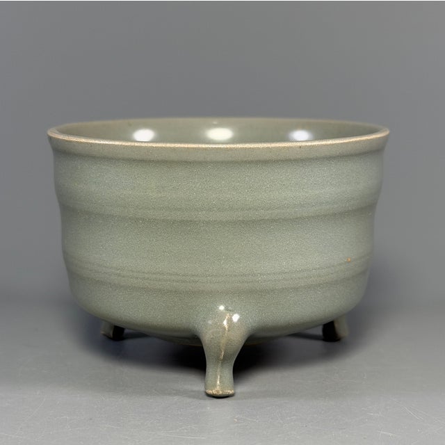 This vintage‑style Chinese Longquan celadon censer stands on three sturdy feet, decorated with delicate horizontal ribbed...