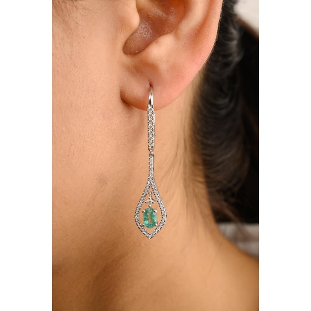 This is part of Chairish’s Fine Jewelry assortment. These modern drop earrings feature striking emeralds encircled by...