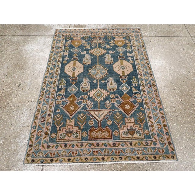 This mid-20th-century Persian Malayer throw rug presents a bold geometric composition across a deep blue-green field. The...