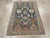 This mid-20th-century Persian Malayer throw rug presents a bold geometric composition across a deep blue-green field. The...