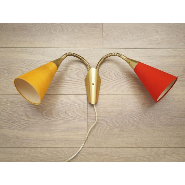 The wall lamp was made in the 1970s, Danish production. Made of metal. Metal in gold colour. Lampshades covered with...