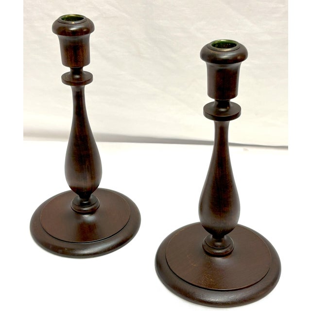 Nice pair of antique turned wood candlesticks from the early 1900's. The have a baluster form body with brass edged candle...