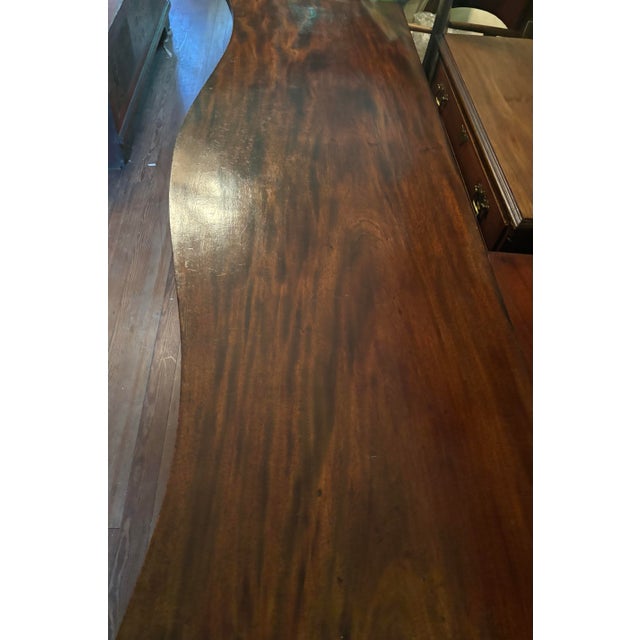 Serpentine English mahogany sideboard with lion head pulls and green felt lining. Late 19th century.