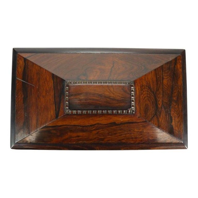 An English Georgian rosewood tea caddy, dating from circa 1830. This antique piece showcases the rich, dark tones and...