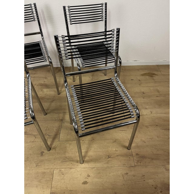 Set of four Sandows 101 chairs with a steel frame and elastic cord seat and backrest, designed by René Herbst and made in...