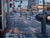 The artwork depicts a bustling city street at twilight, where the interplay of artificial lights reflects off wet...
