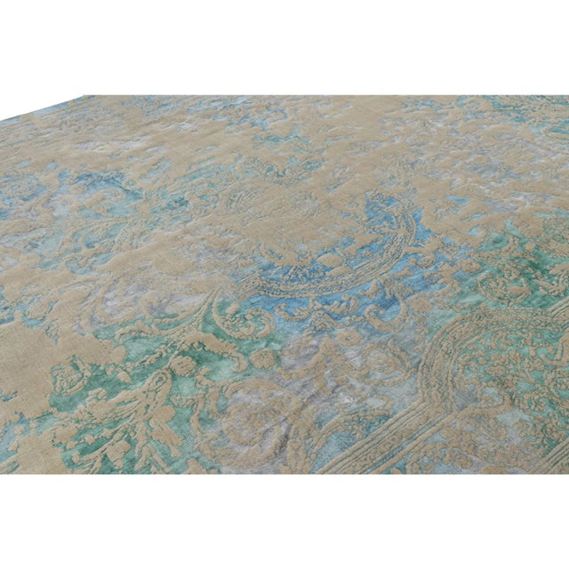 Hand-knotted in wool, this 13x10 modern classics rug from Turkey features beige-brown and blue tones underscore an almost...
