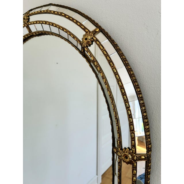 A large vintage Spanish Venetian-style beveled wall mirror, dating to the 1980s. The mirror has a decorative glass frame...