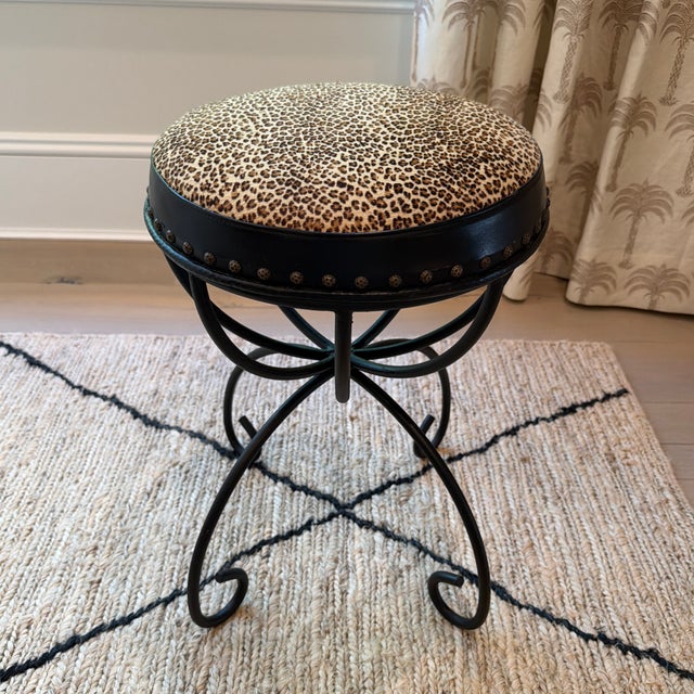 Chic vintage wrought iron stool featuring an unusually decorative looping and scrollwork base. The round upholstered seat...