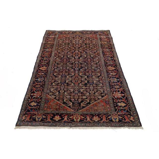 This is a handmade Persian Malayer rug from the 20th century. It features a dark blue field with multicolor accents...