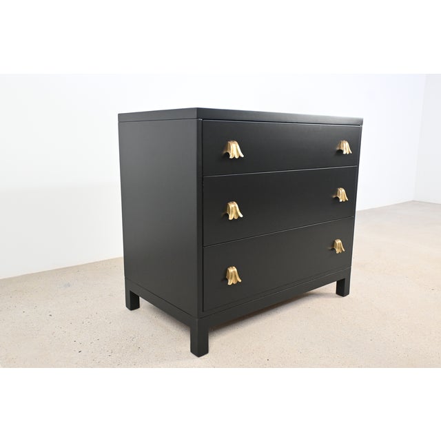 A classic Robsjohn-Gibbings chest for Widdicomb, refinished in its recent history in a smooth black lacquer that...
