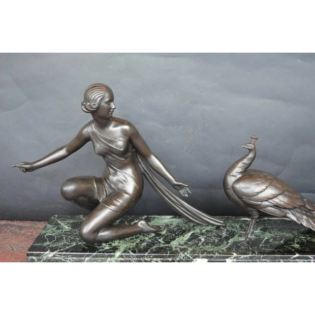 Alexandre Ouline sculpture of a woman with a peacock. Very faintly signed on marble.