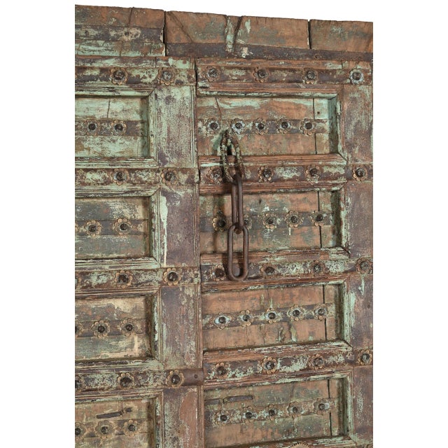 Antique Indian Carved and Painted Teakwood Gujarati Door, each door panel with 8 panels, centered with an iron strap with...